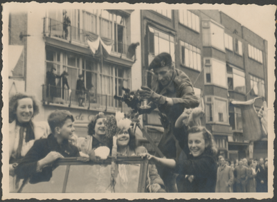 879268 Afbeelding van een geallieerde cameraman, op een legervoertuig in de Potterstraat te Utrecht, tijdens de intocht ...